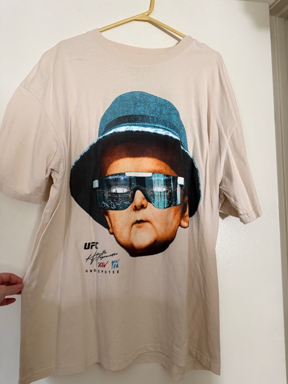 UFC Beige Graphic Tee with Teal Hat and Blue Sunglasses